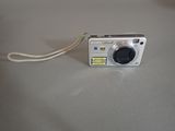 a silver camera sitting on a table with a cord attached to it