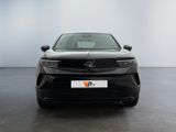 the front of a black car in a room with a white wall