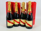 trois bouteilles de champagne devant une boîte rouge