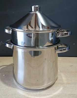 une casserole en argent avec un couvercle, posée sur une table en bois