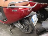 a red scooter parked next to a black motorcycle