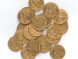 a pile of gold coins sitting on a white surface
