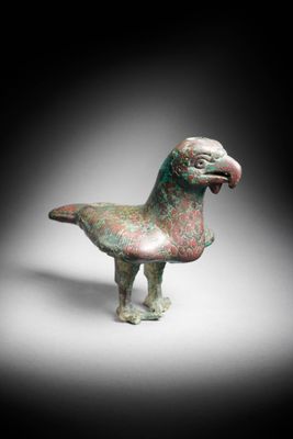 a close up of a bird statue on a white surface
