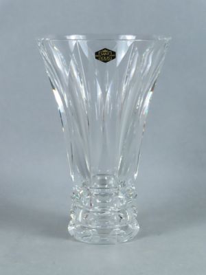 a clear glass vase with a gold emblem on it