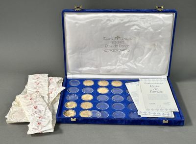 un coffret bleu contenant une collection de pièces d'or et d'argent