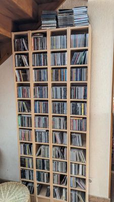 une grande bibliothèque en bois remplie de CD et encore de CD
