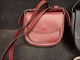 two purses that are next to each other on the floor