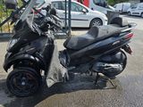 a scooter parked in a parking lot next to a fence