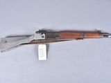 an old gun with a wooden handle on a white surface