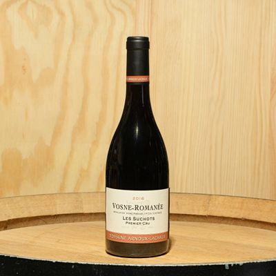 a bottle of wine sitting on top of a barrel
