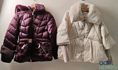 two coats hanging on the wall next to each other
