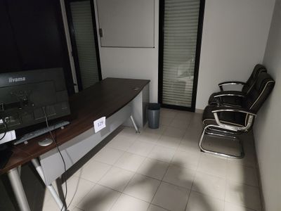 un bureau avec un écran et une chaise dans une pièce