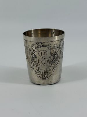 an antique silver cup with a floral design on the rim