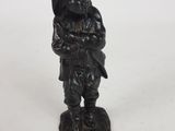 figurine représentant un homme portant un chapeau et un sac sur le dos
