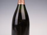 an old bottle of champagne sitting on top of a white table