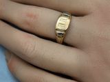 a person ' s hand with a gold ring on it