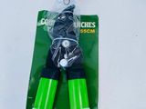 a green pair of scissors on a white table