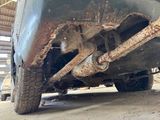 the rear end of a car with rust on it in a garage