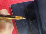 a person holding a pen in their hand near a red wall