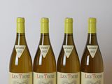 quatre bouteilles de vin sont alignées sur une table en bois