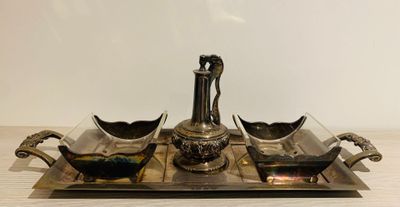 a silver tray with two bowls and a vase on it