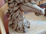 a horse made out of drift wood sitting on a cushion