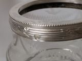a glass jar with a silver lid sitting on a table