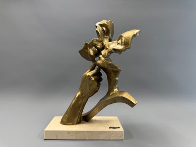 une statue en bronze représentant une femme tenant une fleur, posée sur un socle en bois