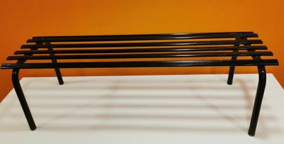 a black bench that is on a white table