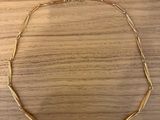 a gold necklace on a wooden surface