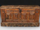 un vieux coffre en bois avec des gravures et des sculptures sur les côtés