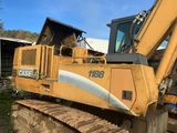 une pelleteuse jaune qui est à l'arrêt dans la terre