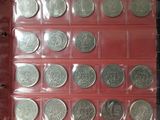 an assortment of silver coins in a red case on a table