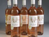 four bottles of wine are lined up on a white surface