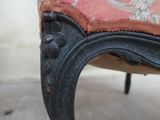 a close up of a chair with a red cushion on it