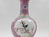 a pink and white vase with a bird on it