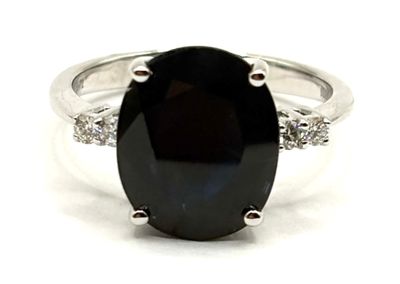 un gros plan d'une bague sertie d'une pierre noire et de diamants