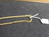 a close up of a gold chain with a tag on it