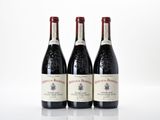 three bottles of red wine are lined up on a white surface
