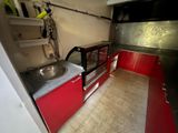 a sink in the middle of a kitchen with red cabinets