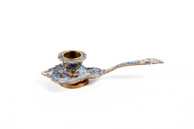 une petite pipe bleue et dorée posée sur une cuillère