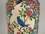 un vase bleu orné d'un oiseau, posé sur une table