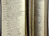 un livre ouvert avec une écriture dessus, posé sur une table
