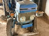 a blue tractor that is parked in a garage