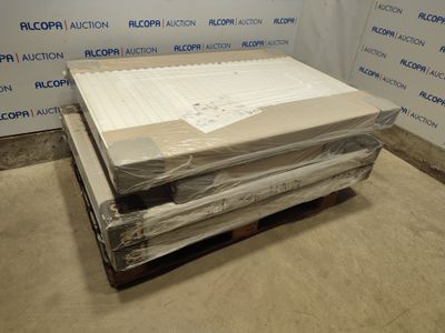 Des cartons contenant des matelas sont empilés sur une palette dans une pièce