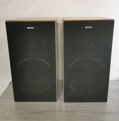 une paire d'enceintes posées sur une table en bois