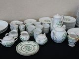 many plates and cups on a table with a black table cloth