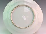 a white and green plate with a tag on it