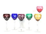 six verres à vin sont alignés sur une surface blanche