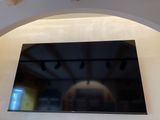 une télévision à écran plat fixée au mur au-dessus d'une cheminée